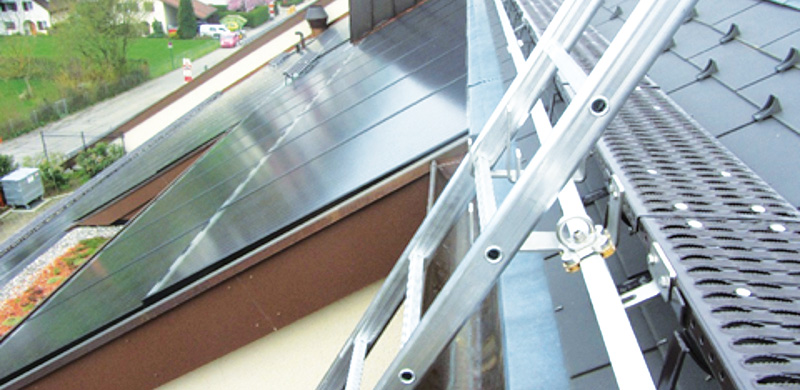 Beispiel Anlegeleiter: Aufstieg zum Steildach mit Photovoltaik-elementen mittels Anstellleiter. 