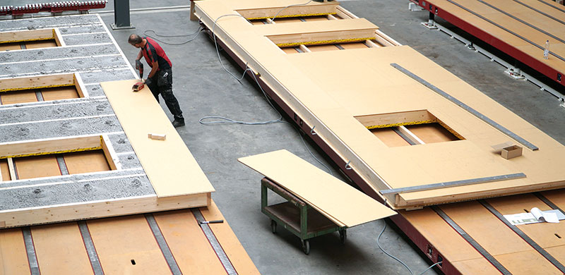 Holzfertigbau: Erst werden die Holzwände mit Dämmung befüllt, danach mit den Platten auf der Innenseite geschlossen.