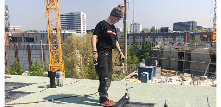 Foto von Dachdeckerin Paula Eberhard beim Schweißen auf dem Flachdach.