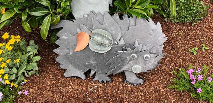 Bild von Schiefer-Igelskulptur, die in einem Garten steht.