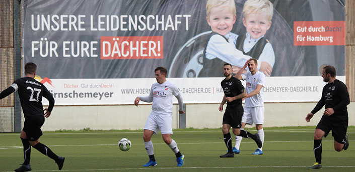 Bild von Spielern beim Fußball mit Werbebanner von Hörnschemeyer im Hintergrund.