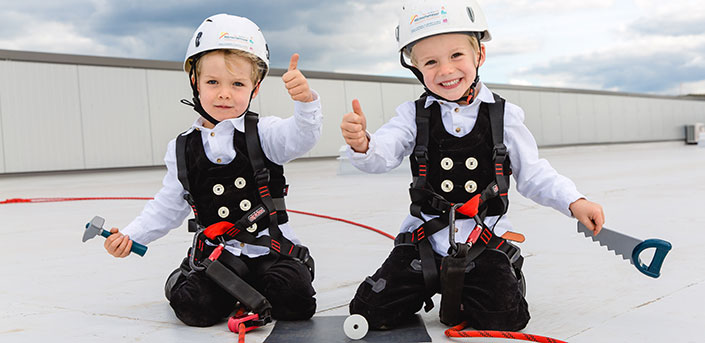 Bild von Hörnschemeyer Zwillingen auf dem Dach, mit Helm und in persönlicher Schutzausrüstung.
