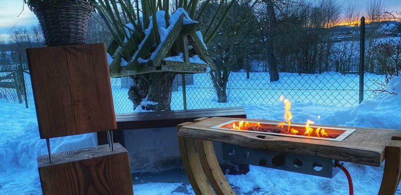 Bild von Feuertisch im schneebedeckten Garten