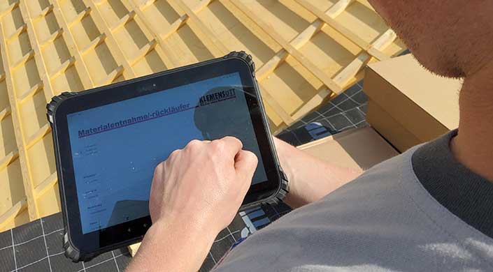Bild von Mitarbeiter auf dem Dach mit Tablet
