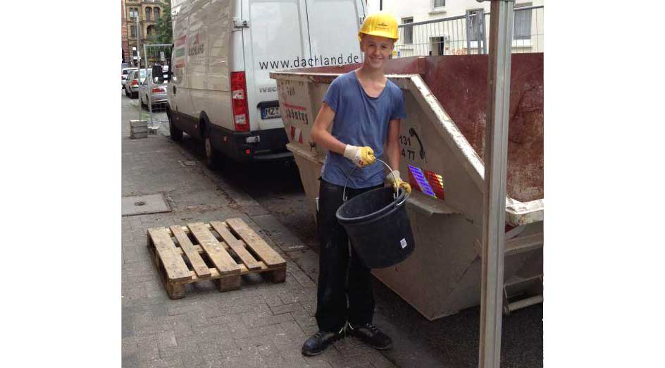 Bild von Florian Luft mit Eimer in der Hand an einem Bauschuttcontainer