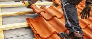 Mehrere orangefarbene Tonziegel sind gestapelt, bereit zur Verwendung auf einem Dach.