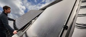Solarmodule auf einem Dach unter blauem Himmel mit einigen Wolken.