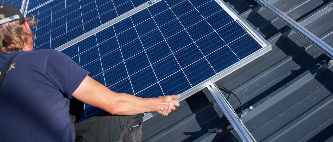 Bild von Dachdecker bei Montage eines Solar-Moduls