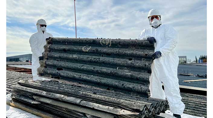 Dachdecker beim Entsorgen von Asbest-Dachplatten