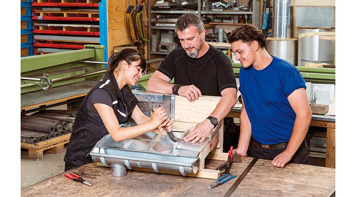 Bild von Meister mit Auszubildenden in der Werkstatt