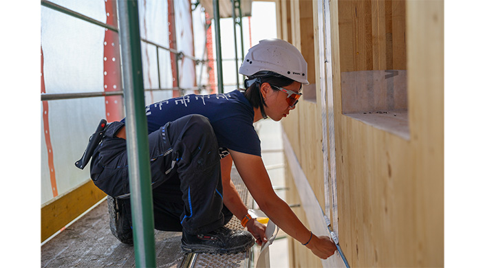 Bild von Zimmerin Qinrui Li bei Fassadenarbeiten