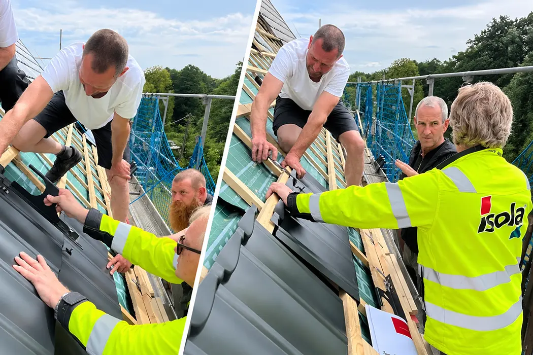 Zwei Personen arbeiten an einer Dachkonstruktion mit Holzlatten und Dachziegeln unter freiem Himmel.