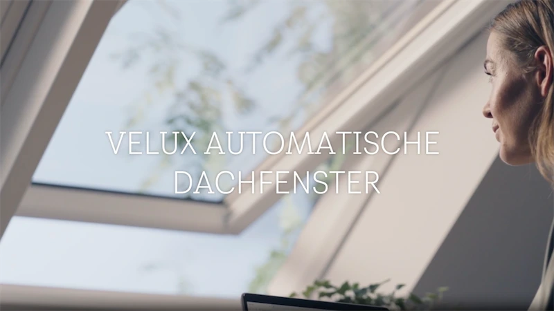 VELUX automatische Dachfenster Frau schaut aus einem automatischem VELUX Dachfenster.